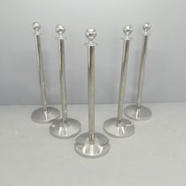 A set of five chrome queuing barrier posts. Height 103cm. Lacking base weights. Some slight dents