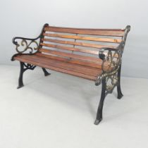 A stained pine slatted garden bench with painted cast iron ends. 125x77x68cm.