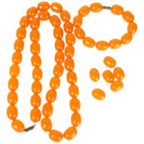 An amber barrel bead jewellery set, comprising necklace and bracelet, bead lengths 19.2mm,