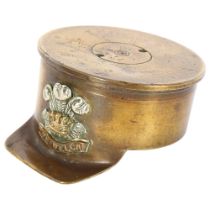 An unusual trench art shell case dated 1915, in the form of a cap with applied "The Welch" badge