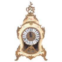 A French mantel clock of shaped form, circular brass dial with enamel shields and Roman numerals,