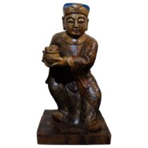 A large Chinese carved wood figure of a merchant, with gilded chinoiserie decoration, on rectangular