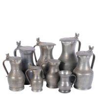 A group of lidded pewter jugs, tallest 26.5cm, and a pewter mug