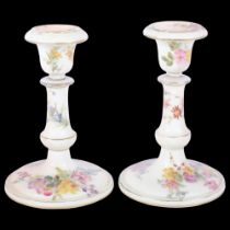 A pair of Royal Worcester Blush Ivory candlesticks, with painted floral spray and gilded decoration,