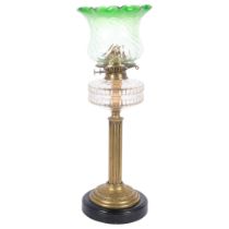 A Victorian brass oil lamp, with shaped green glass shade and glass font, brass fluted column and