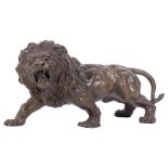 A free-standing bronze sculpture of a roaring lion, H15cm, L32cm