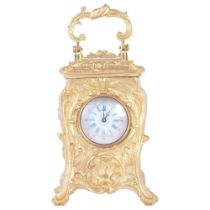 An ornate reproduction miniature gilt-metal carriage clock, with swing handle, height not