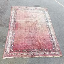 A red-ground Persian carpet. 320x235cm.