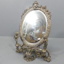 A Rococo style cast brass framed dressing table mirror, with silvered finish, and cherub and and