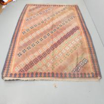 A red-ground Kilim carpet. 244x165cm Faded, but otherwise good condition.