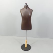 A modern leather covered mannequin on stand, of small male form. Height overall 130cm.