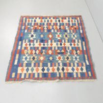 A red and blue-ground Kilim rug. 133x124cm.