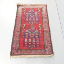 A red-ground Persian prayer rug. 141x86cm.
