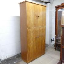 A mid-century oak record / vinyl cabinet, having four bi-fold doors and fitted interior.