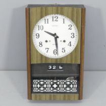 SEIKO - A mid-century 30 day wall clock with 8" dial, date aperture, key and pendulum. 26x44x11cm.
