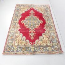 A red-ground Kerman carpet. 220x145cm.