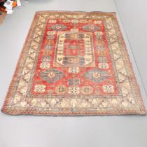 A red and cream-ground Kazak carpet. 235x177cm.