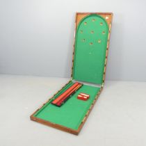 An antique mahogany cased folding Bagatelle game board, with cue and balls. Dimensions (folded)