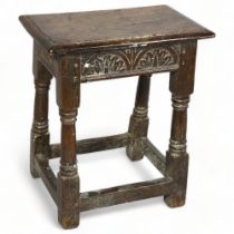 A 17/18th century oak joint stool, with carved rails, and turned baluster legs, height 53cm, top