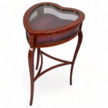 An Edwardian mahogany heart-shaped vitrine table, with inlaid stringing, curved side panels, on