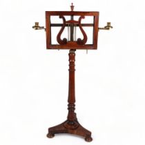 A 19th century rosewood duet music stand, with brass candle brackets, adjustable column and platform