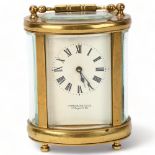 GARRARD - an oval brass-cased carriage clock, case height 11.5cm Small chip in the glass front door,