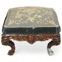 A large Victorian carved oak-framed stool, on elaborate base with lion paw feet, approx 70cm