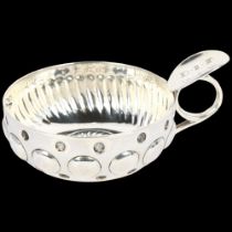 A French silver wine taster, with relief embossed decoration, indistinct maker's mark, bowl diameter