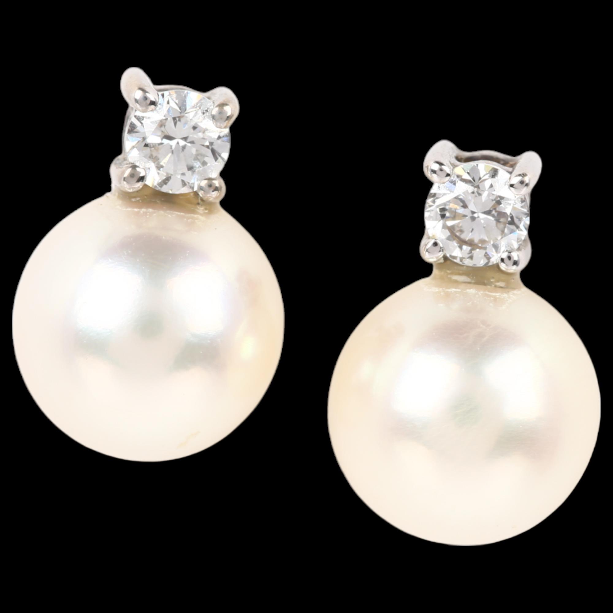 A pair of 18ct white gold whole pearl and diamond earrings, each claw set with 0.07ct modern round