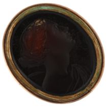 A 19th century glass intaglio seal ring, depicting Classical female profile, in unmarked gold mount,