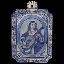 Delft blue and white pottery wall plaque, depicting a musician, dimensions excluding top mount 25.