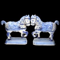 Pair of faience blue and white pottery saddled horses, height 24cm, base length 18.5cm Minor glaze