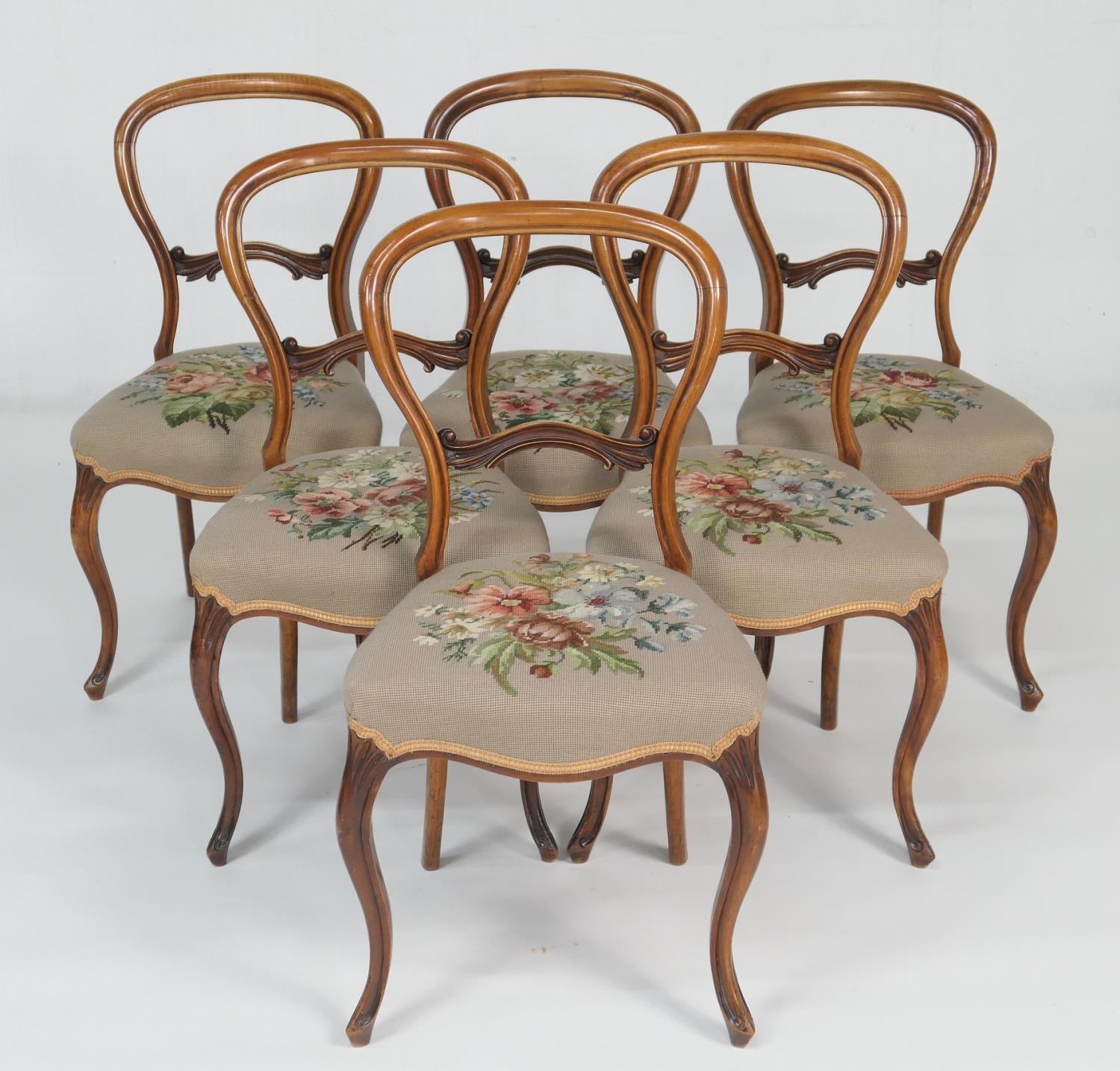 Set of six Victorian walnut balloon back dining chairs, circa 1860, with a carved central bar