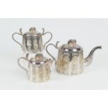 Indian white metal three piece tea service, circa 1900, comprising a lidded teapot with elephant