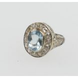 Diamond and aquamarine cluster ring in 18ct white gold, probably American, the oval cut aquamarine