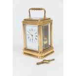 French brass carriage timepiece, white enamelled dial with Roman numerals, the movement striking the