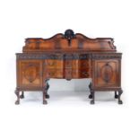 Chippendale Revival mahogany serpentine sideboard, circa 1910, having a carved moulded back, two