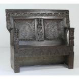 Carved oak hall settle (made up), with 17th Century and later elements, having a two deep recessed