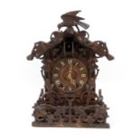 Swiss carved limewood cuckoo clock, circa 1900, chalet form surmounted with a bird, the dial with
