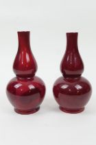 Pair of Bernard Moore red flambe double gourd vases, one numbered 1069 (restored at the neck), the