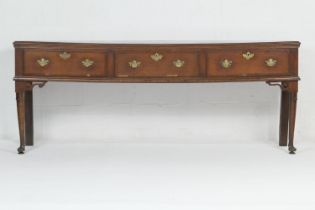 George II oak low dresser, circa 1750, having three drawers crossbanded in walnut and with brass