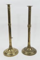 Two brass altar sticks, 19th Century, one having a wax ejector, both with circular bases, height