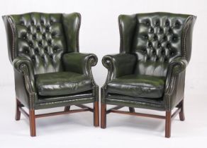 Pair of green leather upholstered deep buttoned wing armchairs, with square section supports, height