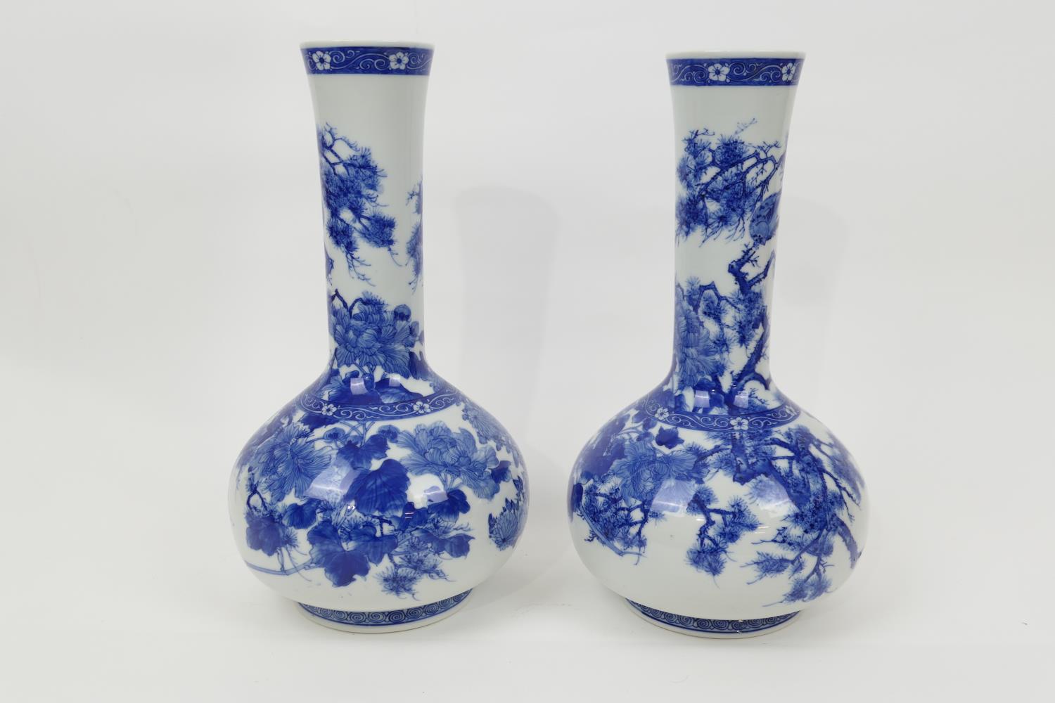 Pair of Japanese blue and white bottle vases, Taisho (1912-26), decorated with peony, fir and