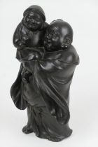 Chinese bronze Buddha, late 18th/early 19th Century, cast carrying a boy, marked to the base, dark