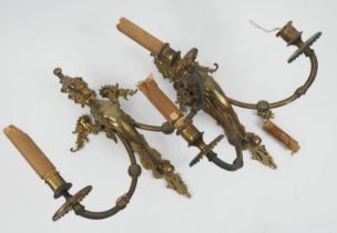 Pair of cast and pressed brass griffin twin branch wall lights, height 40cm, spread 33cm (Please