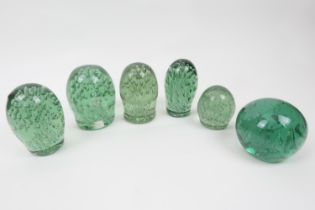 Six Victorian green glass oval and spherical dumps, each encasing a myriad of bubbles, the tallest