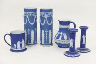 Small selection of Wedgwood dark blue jasper wares comprising two cylinder vases, 25cm and 24.5cm; a