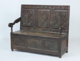 Victorian carved oak box settle, circa 1890, profusely carved three panel back, the base with lift