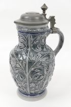 Decorative German glazed pitcher, having a hinged pewter cover, the body relief moulded throughout